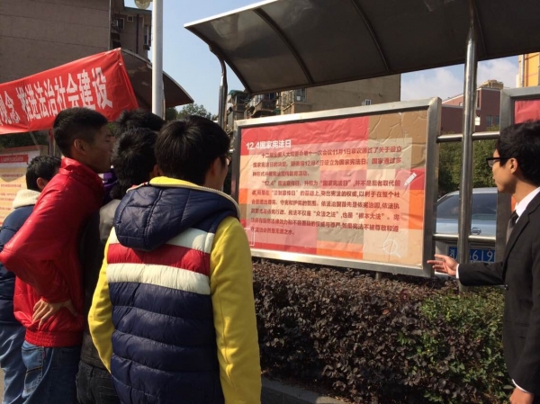 员工在宪法日宣传栏前.jpg